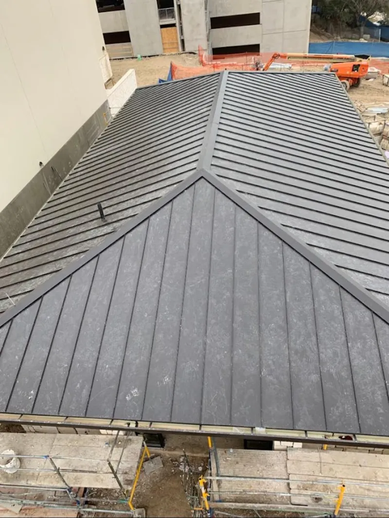 Commercial metal roof construction with crane equipment in Anthem