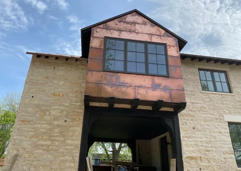 Copper metal panel facade on a stone building for Roof Repair in Anthem